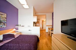 a bedroom with a bed and a flat screen tv at 4Seasons﻿ Apartments Cracow in Kraków