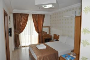 a hotel room with a bed and a window at İskele Otel in Tasucu