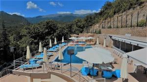 - une piscine avec des parasols, des chaises, des tables et des chaises dans l'établissement Nostos Hotel, à Kato Loutraki