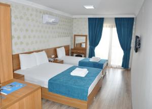 a hotel room with two beds and a mirror at İskele Otel in Tasucu