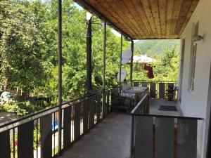 a balcony with a bench and a view of trees at Chveni Ezo in Ambrolauri