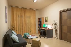 un soggiorno con divano e scrivania con computer di Dreamcatcher Villa a Pastida