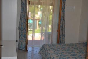 a bedroom with a bed and a sliding glass door at Hotel Danila in Portoferraio