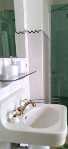 a white bathroom with a sink and a mirror at Suite Florencia in Santa Clara