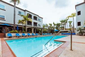 a swimming pool with blue chairs and a building at Tamarack Beach Hotel in Carlsbad
