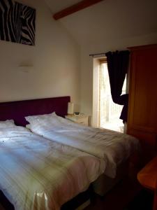 - un lit dans une chambre avec fenêtre dans l'établissement Lakeview at Lodge Farm, à Norwich