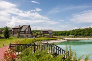 une maison sur une colline à côté d'un lac dans l'établissement Quba Palace Hotel & Golf Resort, à Quba