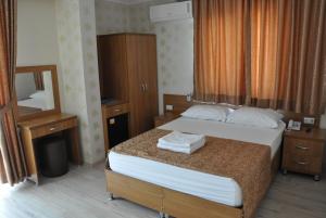 a hotel room with a bed and a mirror at İskele Otel in Tasucu