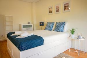 ポルトにあるGreen Suiteのベッドルーム(青い枕の大きな白いベッド付)