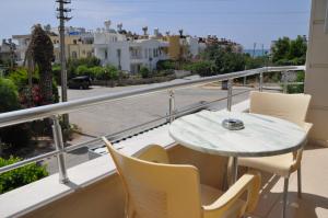 a table and chairs on a balcony with a view of a street at İskele Otel in Tasucu