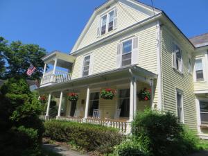 a large white house with flowers on the porch at Cooperstown Bed and Breakfast in Cooperstown