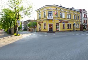 a yellow building on the corner of a street at The Lion Rooms in Ustroń