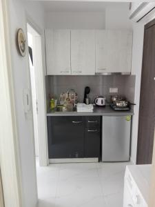 una cucina con armadi bianchi e piano di lavoro nero di Milla Lux 1 a Paralia Katerinis