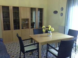 a dining room table and chairs with a vase of flowers on it at Attico Belvedere in Castellammare del Golfo