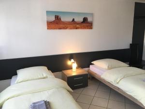 een kamer met 2 bedden en een tafel met een lamp bij Studio Lora RM 1221 in Saint-Louis