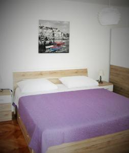 - une chambre avec un lit et une couverture violette dans l'établissement Apartment Nizic, à Primošten
