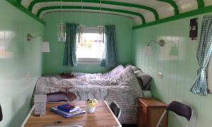 ein kleines Schlafzimmer mit einem Bett und einem Tisch in der Unterkunft Bed & Breakfast ARKEN AE in Zuiderwoude
