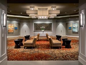 a lobby with couches and tables and a large rug at The Hotel at Auburn University in Auburn