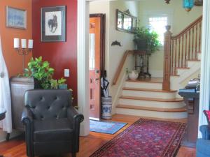 a living room with a chair and a staircase at Cooperstown Bed and Breakfast in Cooperstown