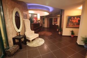 a living room with a chair and a mirror at Delfini Hotel in Menídion