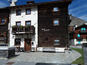un edificio con una panchina davanti di Baita Francisi a Livigno