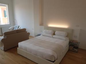 a bedroom with a large bed and a couch at Casa Tea in Bologna