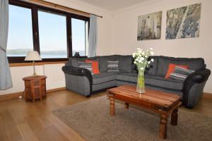 a living room with a couch and a table with a vase of flowers at Clydeside Villa in Dunoon