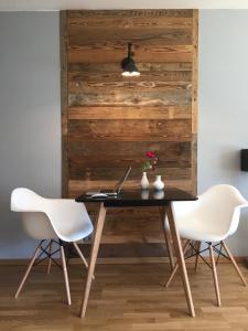 a desk with a laptop and two white chairs at 21st Appartement in Düsseldorf