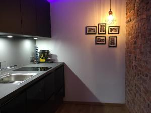 una cocina con fregadero y algunas fotos en la pared en 21st Appartement en Düsseldorf