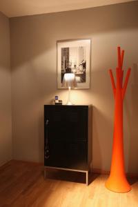 zwei orangefarbene Vasen auf einer Kommode mit einer Lampe in der Unterkunft 21st Appartement in Düsseldorf