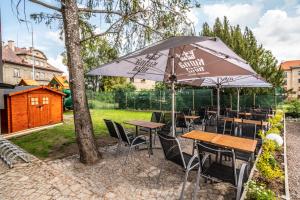 un patio con tavoli, sedie e ombrellone di Hotel Apartments Benešova 6 a Kutná Hora