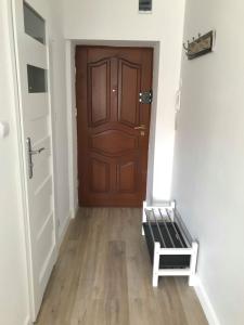 een hal met een bruine deur en een houten vloer bij Apartament Olsztyńska Giżycko in Giżycko