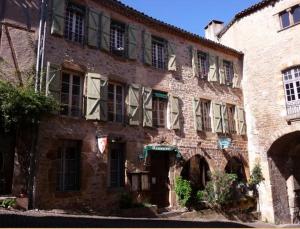 an old brick building with a bunch of windows at Chambres d'hôtes l'Escuelle des Chevaliers in Cordes-sur-Ciel