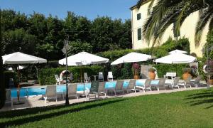 un grupo de sillas y sombrillas junto a una piscina en Albergo Roma, en Casciana Terme