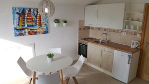 a small kitchen with a white table and chairs at Apartments Crikvenica in Crikvenica