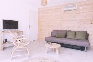 a living room with a couch and a chair at Apartamentos Catharina Maria in Cala Llonga