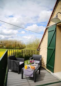 un patio avec deux chaises et une table sur une terrasse dans l'établissement equihome, à Écommoy