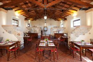 a restaurant with wooden tables and chairs in a room at Agriturismo Grazia in Orbetello