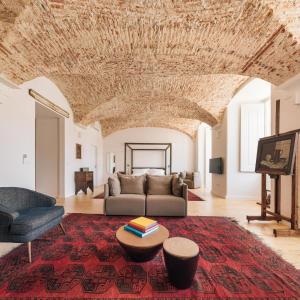 uma sala de estar com um sofá e uma mesa em The Visionaire Apartments em Lisboa