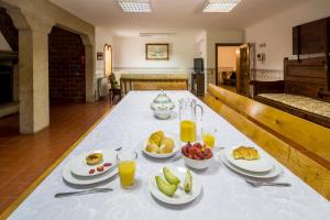 a table with plates of food and glasses of orange juice at Gião - Porto Green&Pool Villa in Gião
