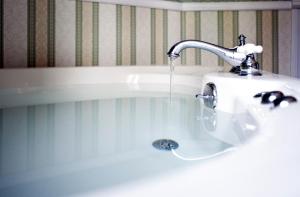 un lavandino in bagno con acqua che scorre da un rubinetto di Old Rittenhouse Inn a Bayfield