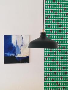 una lámpara negra colgada en una habitación con una pintura en Dimora Hostel en Agrigento