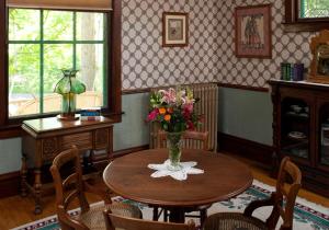 a room with a table with a vase of flowers on it at Old Rittenhouse Inn in Bayfield