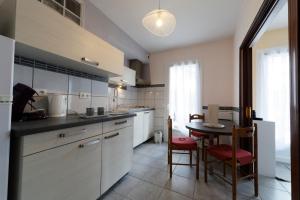 a kitchen with a table and a dining room at Villa Les Bruyères in Saint-Joseph-de-Rivière