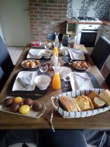 una mesa con un montón de alimentos de desayuno en ella en La Hulotte au Col Haut en Audrehem