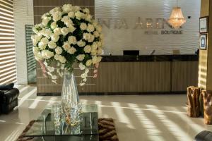 un jarrón lleno de flores blancas sobre una mesa de cristal en Hotel Punta Arena Spa Boutique en Arauca