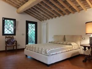 a bedroom with a bed and a table and windows at Agriturismo Le Cerbonche in Rosignano Marittimo
