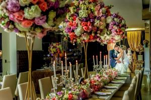 a bride and groom standing in front of a table with flowers at Hotel Punta Arena Spa Boutique in Arauca