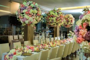 a long table with white chairs and flowers on it at Hotel Punta Arena Spa Boutique in Arauca