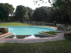 una gran piscina en un patio con rocas en Agriturismo Tisignana, en Roccastrada